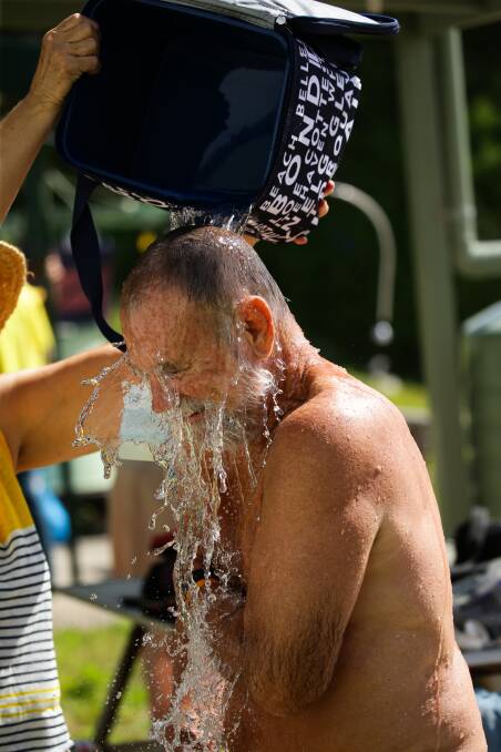 REFRESHING: Author and long-time island visitor John "Stinker" Clarke is given an impromptu shower after a swim. Picture: Jonathan Carroll