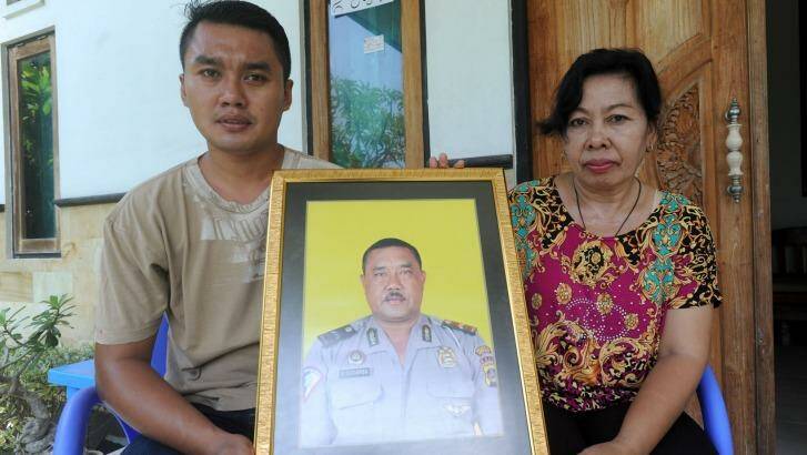 The widow of Wayan Sudarsa, Ketut Arsini, and her son Kadek Toni, hold a portrait of the police officer who was killed on Kuta beach.  Photo: Alan Putra
