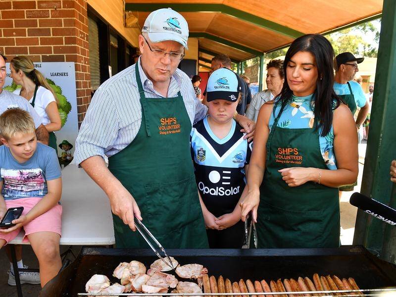 Prime Minister Scott Morrison helped cook sausages at his local polling booth in Sylvania.