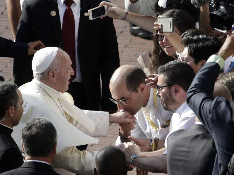 A Catholic faithful kisses the hand of Pope Francis as he arrived for a World Youth Day mass.