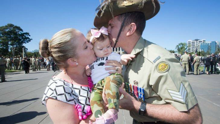 Reunited: Sergeant Adam Keegan with wife Kristi and baby Emerson. Photo: James Boddington