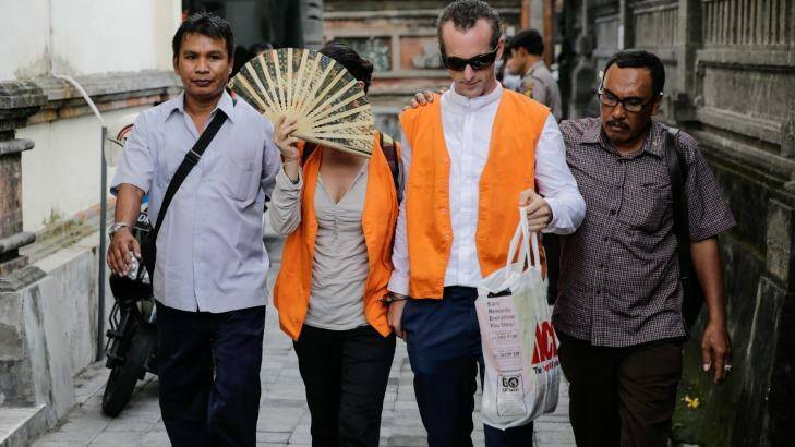 Sarah Connor, who covered her face with a fan, and David Taylor as they arrive at Denpasar Court. Photo: Agung Parameswara