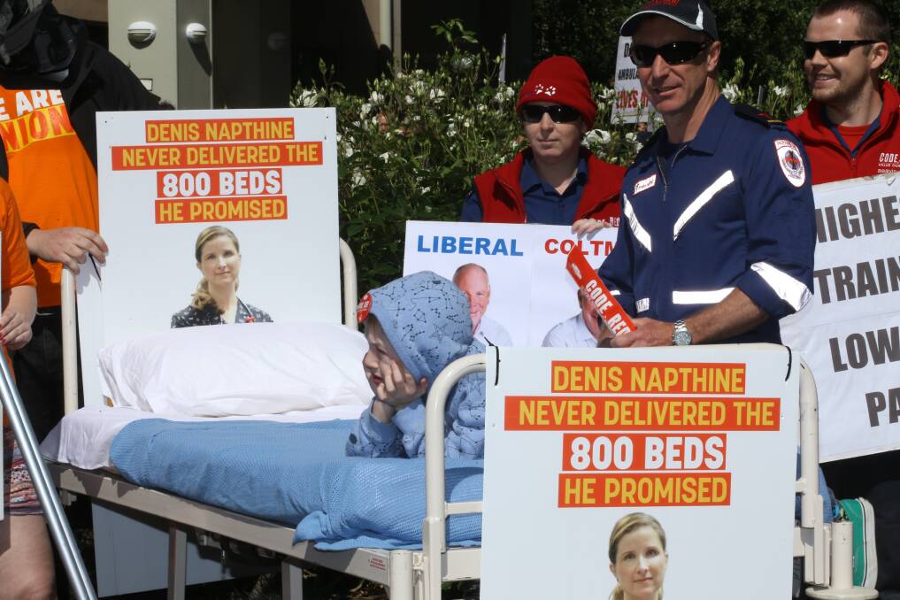 DISGRUNTLED: Ambulance and health workers protest outside the Liberal Party state election launch.