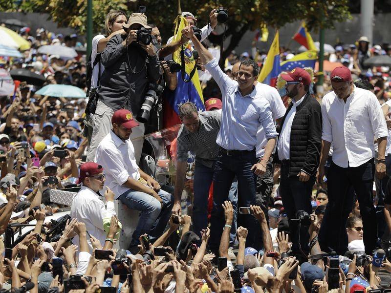 Rival political factions are taking the streets in Venezuela as the nation is hit by blackouts.