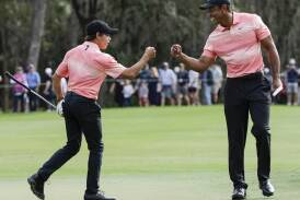 Charlie Woods, here bumping fists with dad Tiger, has missed out on his bid to make the US Open. (AP PHOTO)