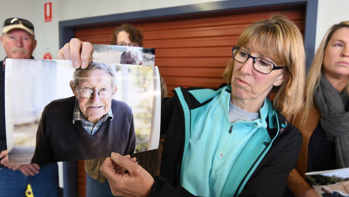 Helen holds up a picture of her missing father Albert Smith at a police briefing.