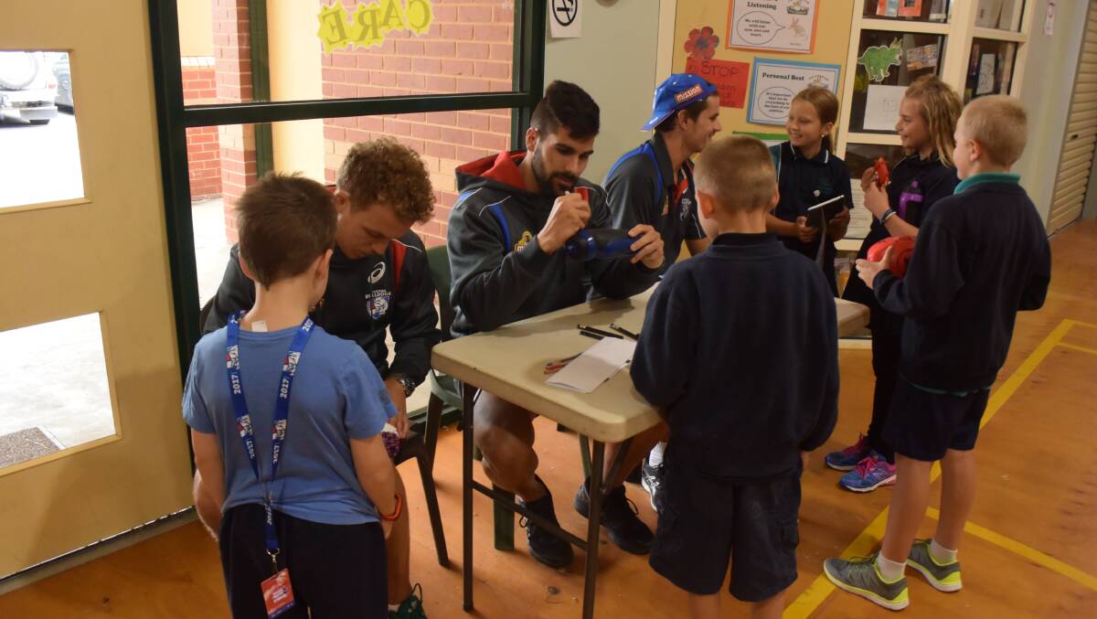 The Western Bulldog players signing merchandise. 
