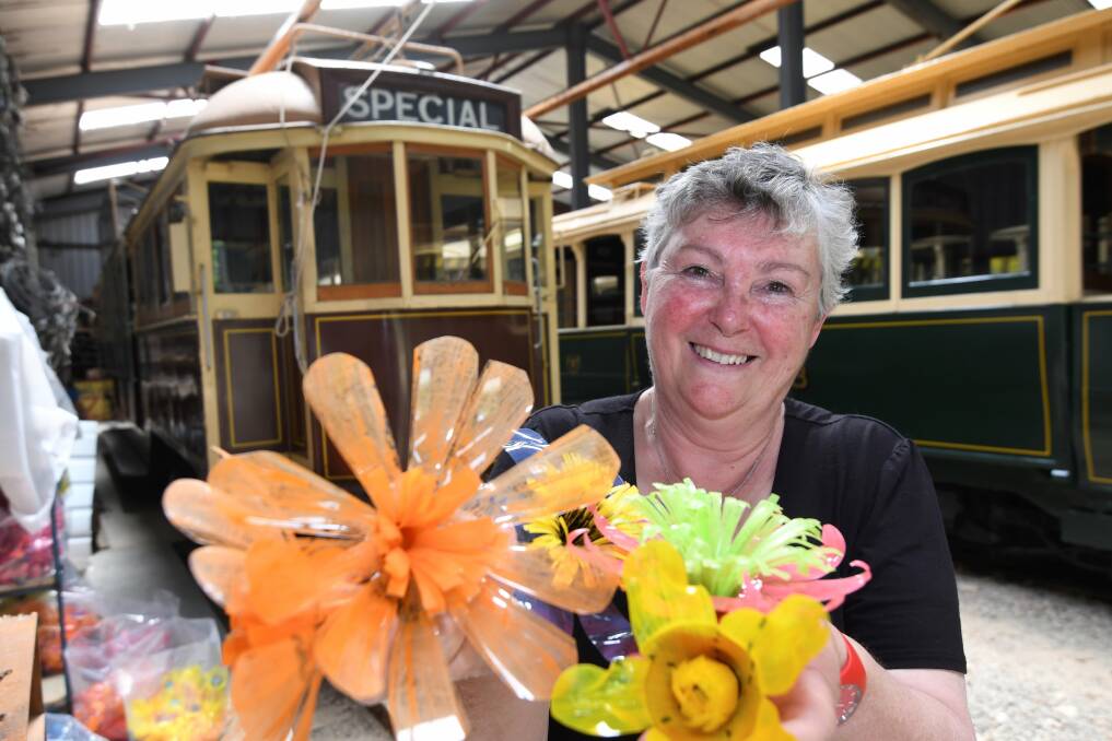 CREATIVE: Floral tram project coordinator Pam Waugh with some of the colourful flowers created from recycled plastic bottles. Picture: Lachlan Bence 