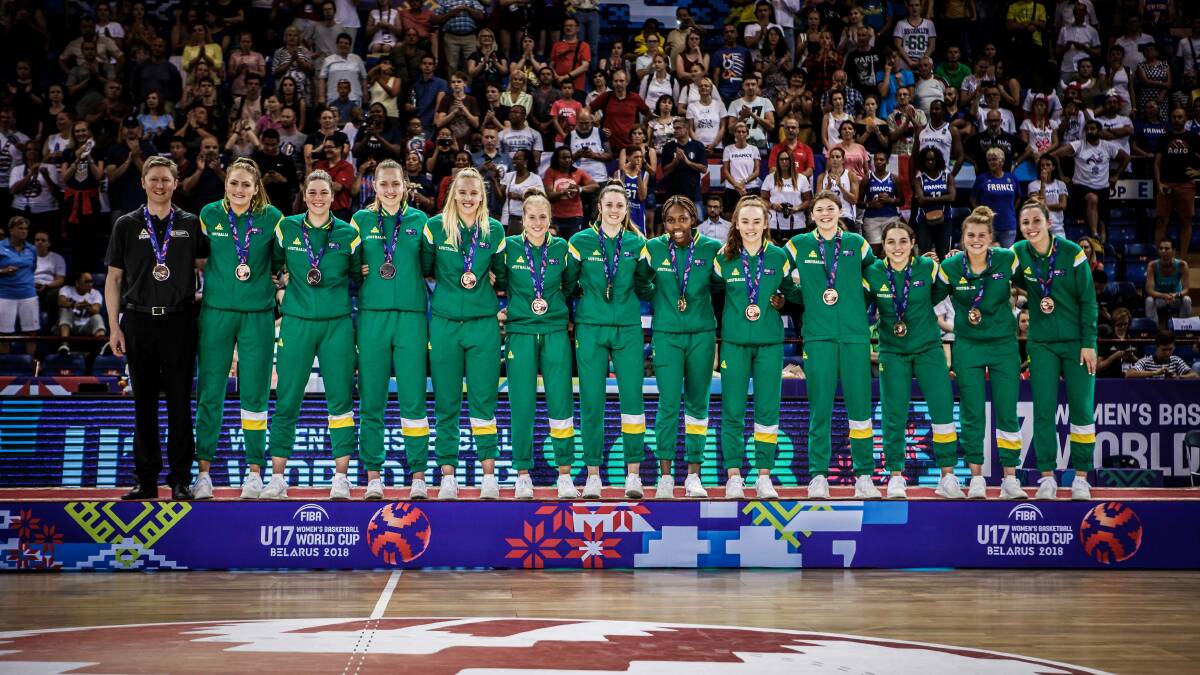 ACHIEVEMENT: Georgia Amoore (third from the right) with her 11 Australian teammates and coach standing proudly with their bronze medals. Picture: FIBA