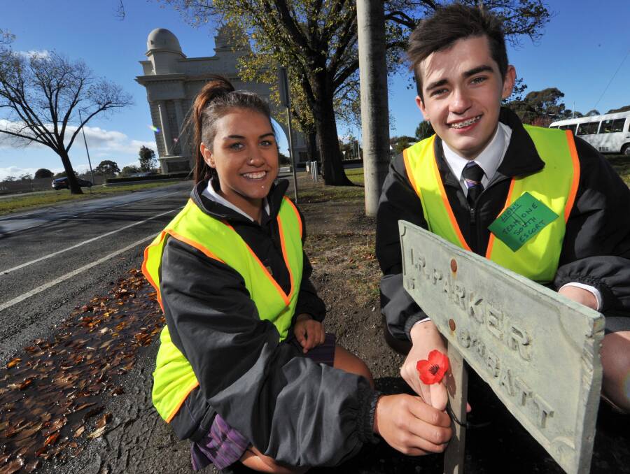 RESPECT: Phoenix P12 Community College students Amber Barker-Lovett and Jayke McPherson attach a poppy to one of the plaques along the Avenue of Honour. PICTURE: JEREMY BANNISTER