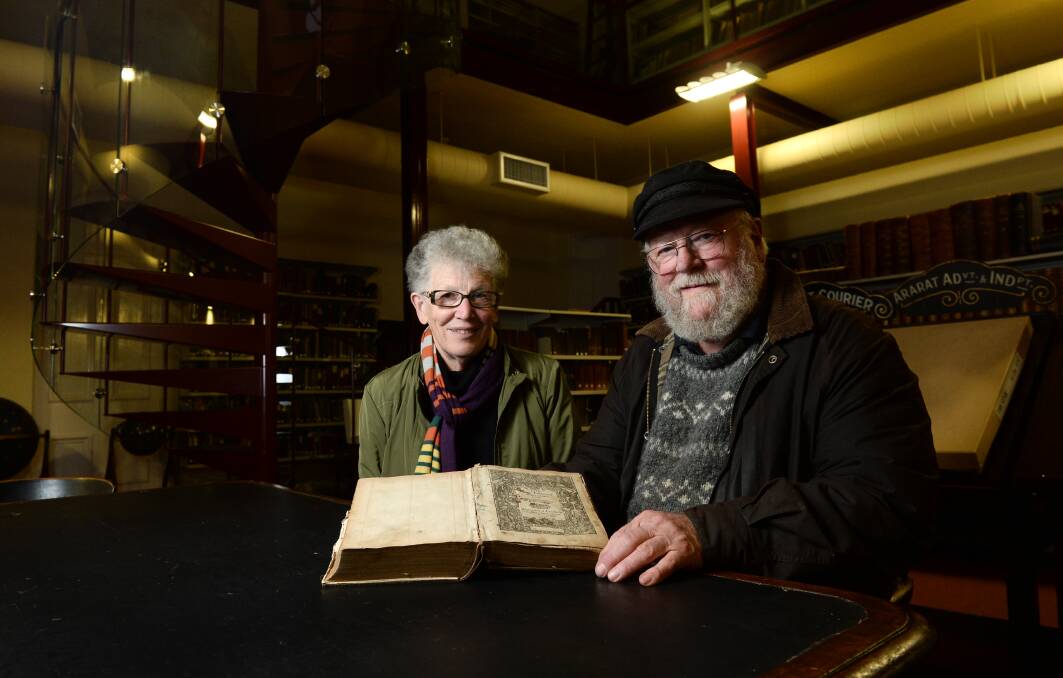 Ballaarat Mechanics’ Institute volunteers Marion Blythman and Roger Burrows with the rare 1585 'Breeches Bible'. PICTURE: ADAM TRAFFORD
