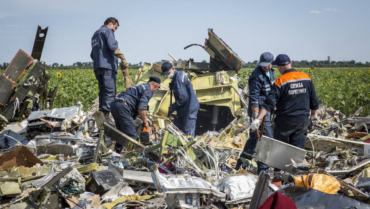 Ukrainian rescue servicemen inspect part of the wreckage of Malaysia Airlines flight MH17. PICTURE: GETTY IMAGES