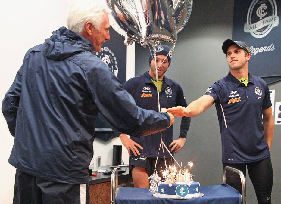 GOOD EFFORT: Carlton’s Dale Thomas and Marc Murphy present Mick Malthouse with a cake to mark his upcoming 700th AFL game as a coach on Friday. PICTURE: GETTY IMAGES
