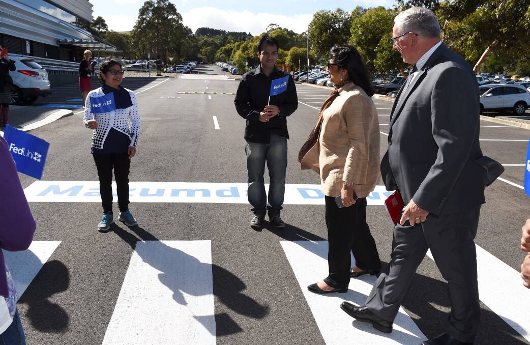 Former student: Kiran Mazumdar-Shaw and university chancellor Dr Paul Hemming cross the newly named Mazumdar Drive. PICTURE: LACHLAN BENCE