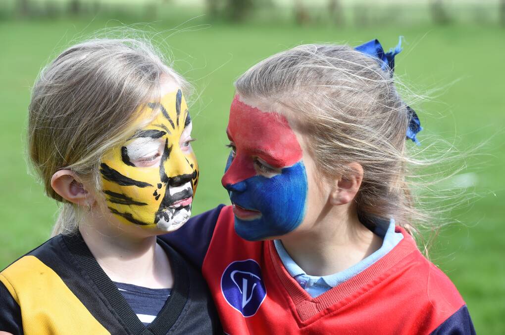 No problem: Tehya Seccull, 8, and Sophie Boyd, 10, are friends despite their teams facing off in Saturday’s grand final.
PICTURE: LACHLAN BENCE