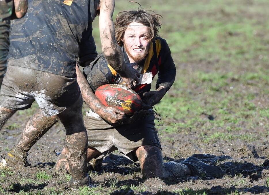 Bacchus Marsh's Liam Baker battles through the Wendouree Reserve mud on Saturday.