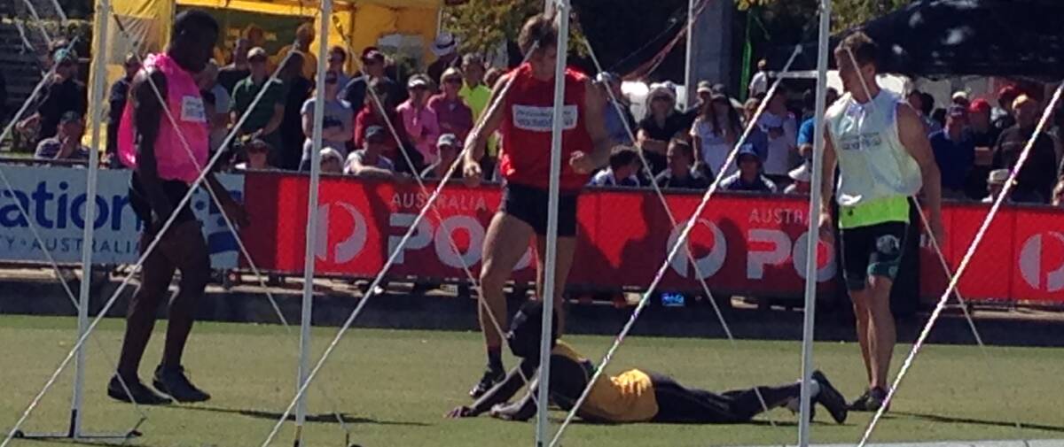 Fellow runners converge on backmarker David Afath after his broke down with a hamstring injury in the Stawell Gift third heat. Photo: Melanie Whelan 