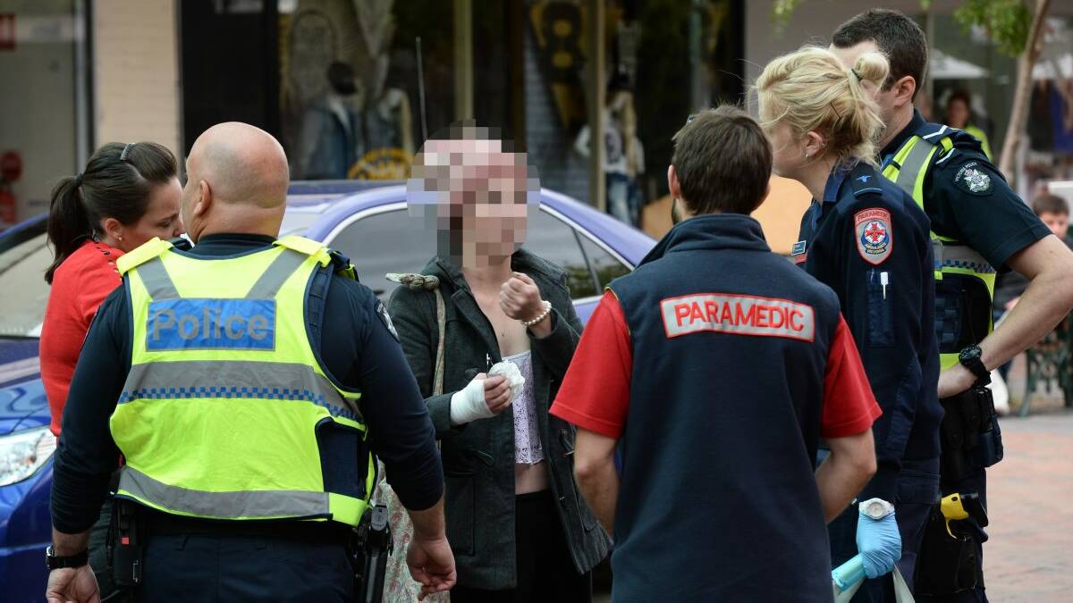 Detectives, paramedics and uniformed police speak to the alleged victim yesterday. Picture: ADAM TRAFFORD