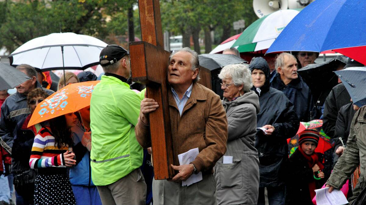 Neville Prenc and Greta Kelly carry the cross during the Good Friday Way of the Cross march. PICTURE: JEREMY BANNISTER