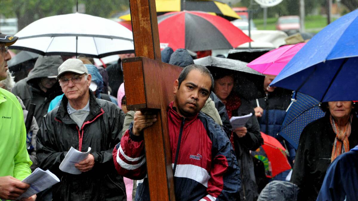 Henry Kalios carries the cross during the Good Friday Way of the Cross march. PICTURE: JEREMY BANNISTER