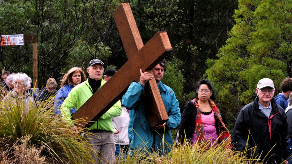 Trevor Smith and Shane Donnithorne carry the cross up to the Black Hill lookout. PICTURE: JEREMY BANNISTER