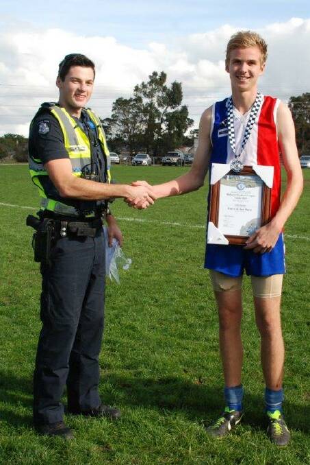 Constable Daniel Milne presents Sean Bourke of East Ballarat with his spirit of sport award.