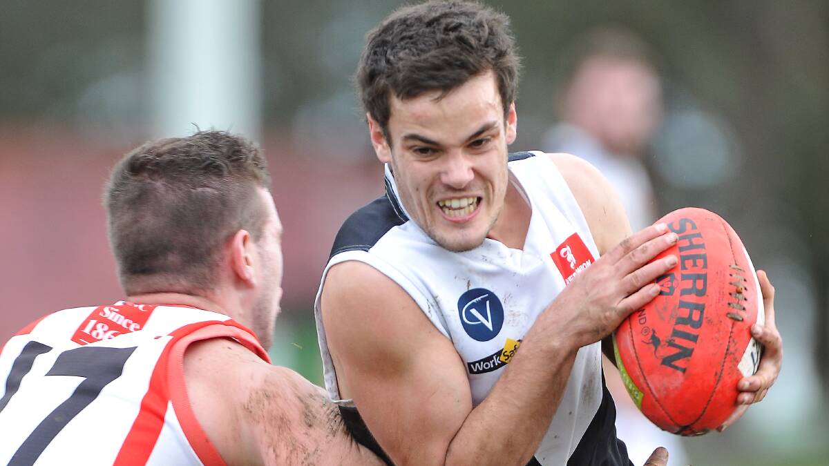 North Ballarat City’s Jayden Orr tries to fend off a tackle against Ballarat. Picture: Lachlan Bence