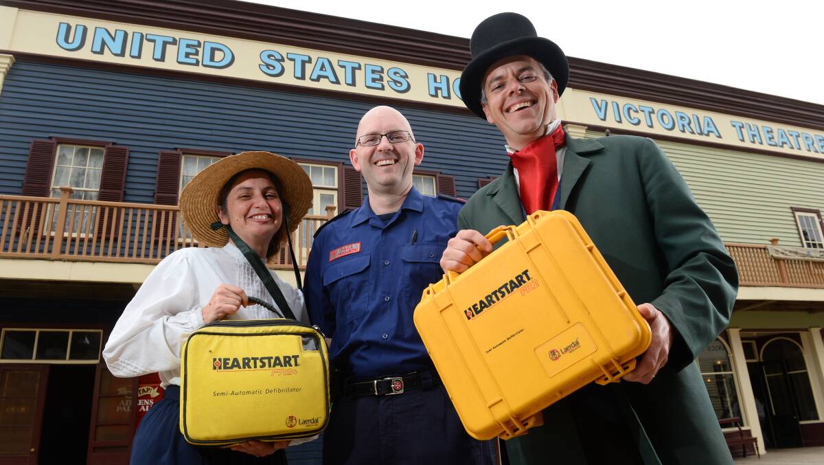 Serena Ioannucci and Jarrod Page, of Sovereign Hill, flank Ambulance Victoria MICA paramedic Simon Vendy during his inspection of Sovereign Hill’s public access defibrillators, none of which has ever had to be used. PICTURE: ADAM TRAFFORD
