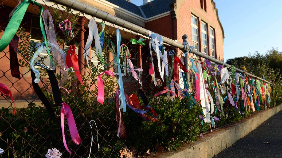 Ribbons tied to the fence of the old St Alipius School show support for the children who were abused. 
