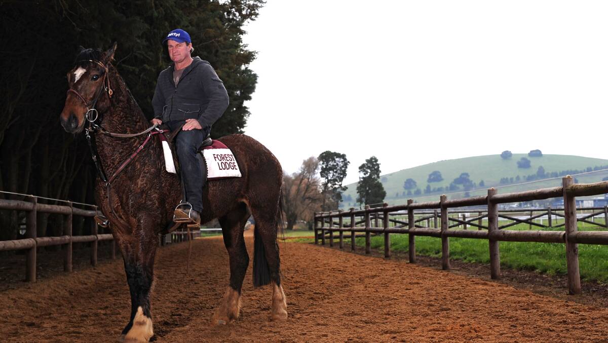 Darren Weir and “Bart” make their way back to the stables after overseeing morning trackwork in Ballarat to the backdrop of Mt Pisgah. PICTURE: Getty Images