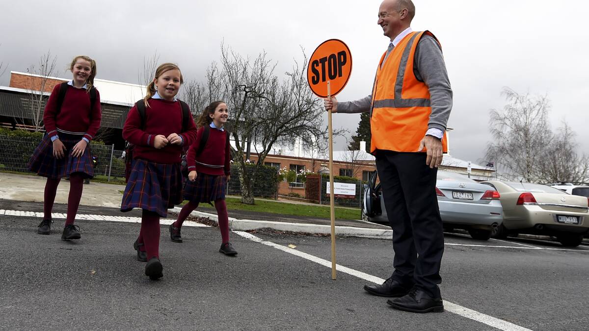 St Francis Xavier Primary School principal Paul Bissinella ensures Milly Sharp, Maddie Bolt and Kate McClure cross the road safely. PICTURE: JUSTIN WHITELOCK
