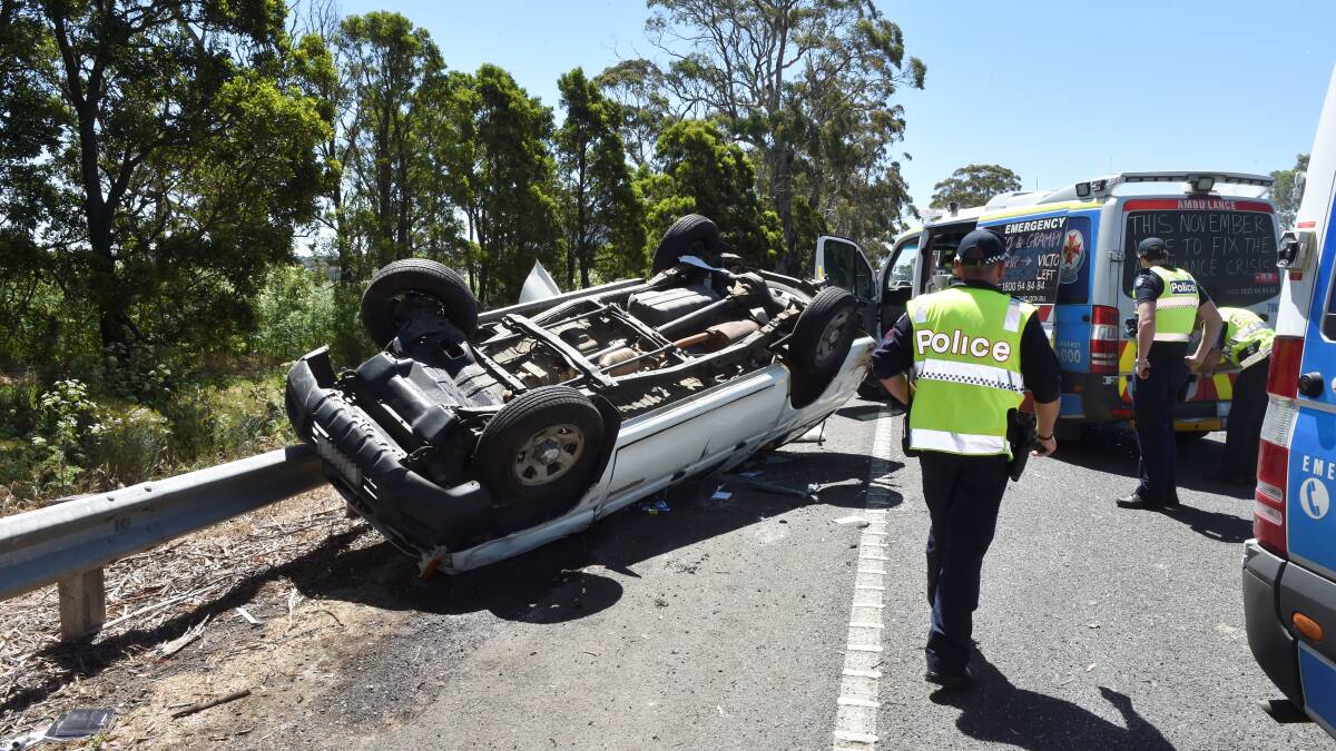 A man has crawled out the back of his vehicle after it rolled over on the Midland  Highway near Buninyong on Friday.