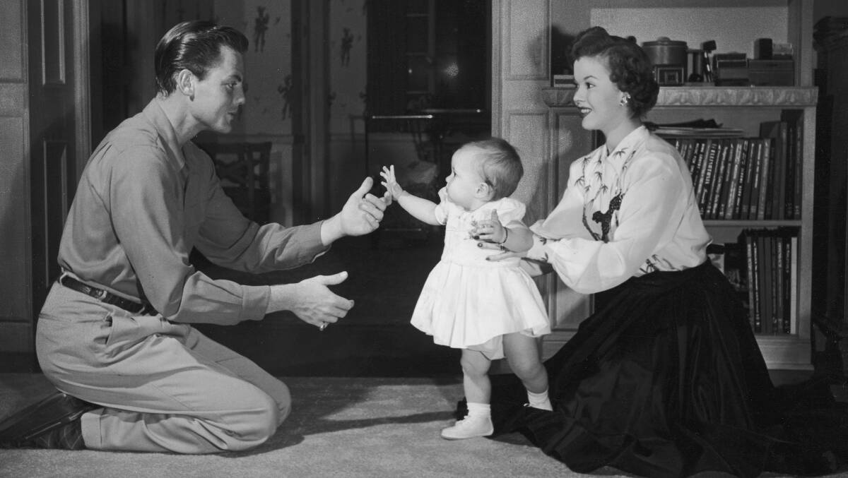 Shirley Temple and her first husband John Agar play with their infant daughter, Linda Susan, in the living room of their home in 1948. Picture: Getty Images