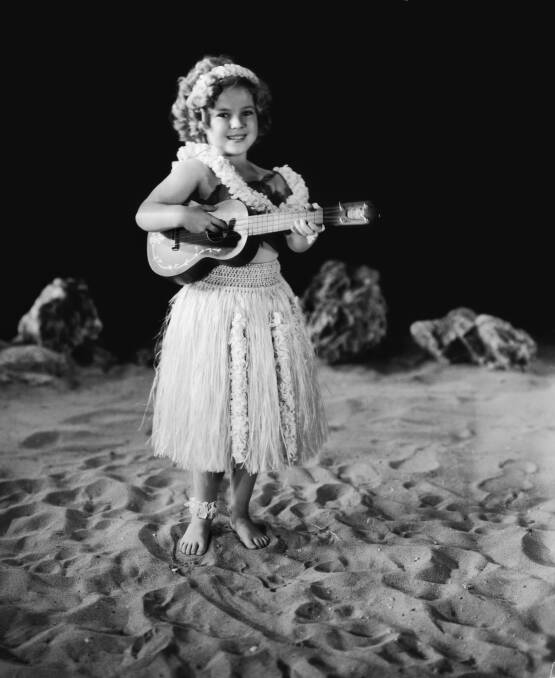 Shirley Temple wears a grass skirt and plays a ukulele in a promotional portrait for the musical 'Captain January' in 1936. Picture: Getty Images