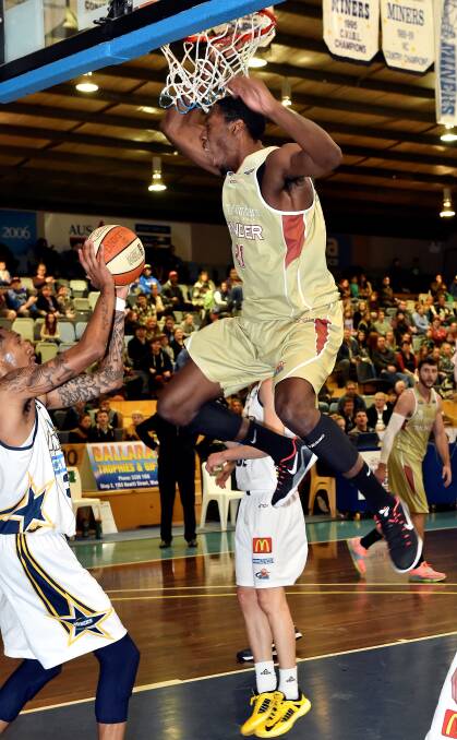 Ken Horton of the Ballarat Miners grabs the ball as flashy American Tyrone Lee screams at the Miners while making a slam dunk for NW Tasmania at the Minerdome.