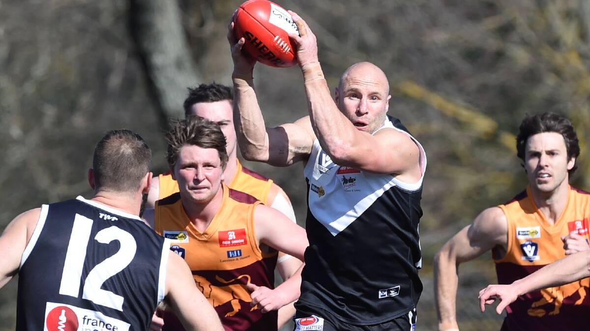 North Ballarat City’s Jarrod Edwards finds the ball in between in his former teammates. 