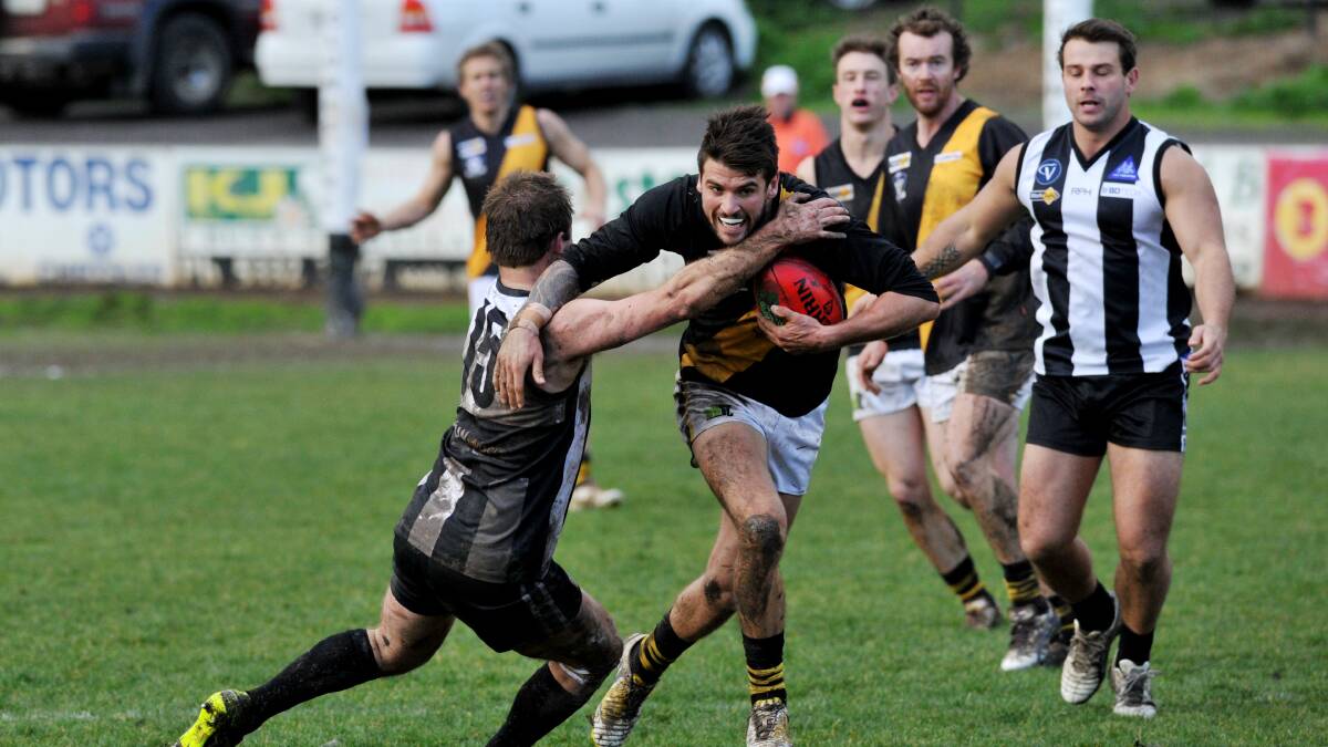 Chris Quinlan (Springbank) and Bob Hind (Clunes) lock horns in the Magpies’ upset win over the Tigers on Saturday. 