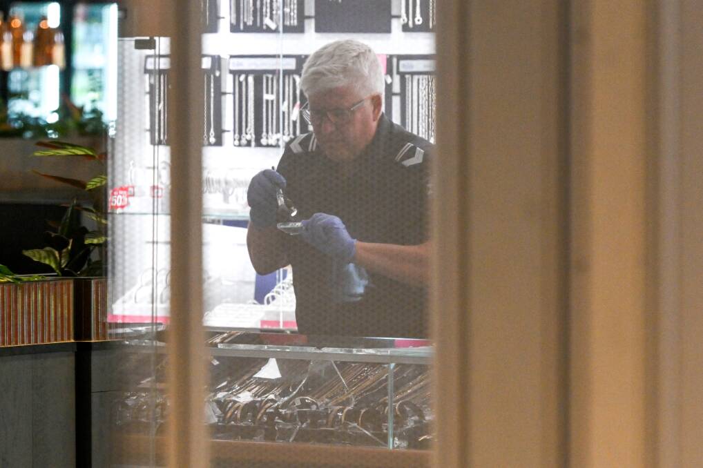 A crime scene officer examines a smashed display case at the Wangaratta Prouds on February 1. File photo