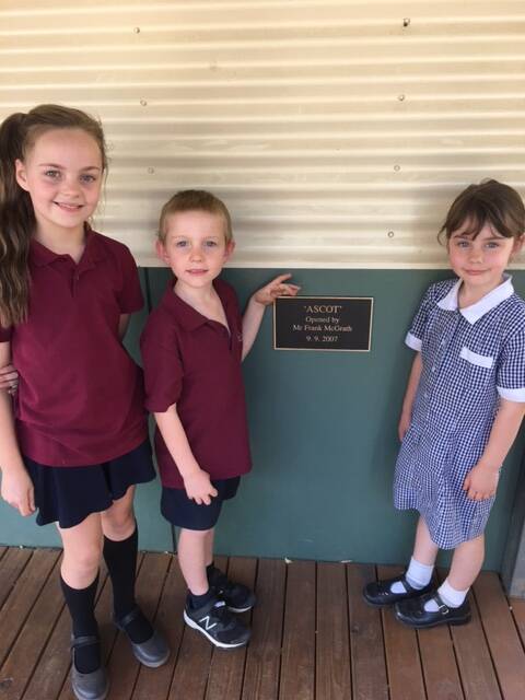 HISTORY: Three pupils show off the schools commemorative plaque. 