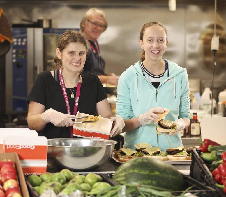 
Julie Vorstenbosch and Miranda Spiller with Dragan Simic (background) make burgers at Breezeway. Picture: Luke Hemer 