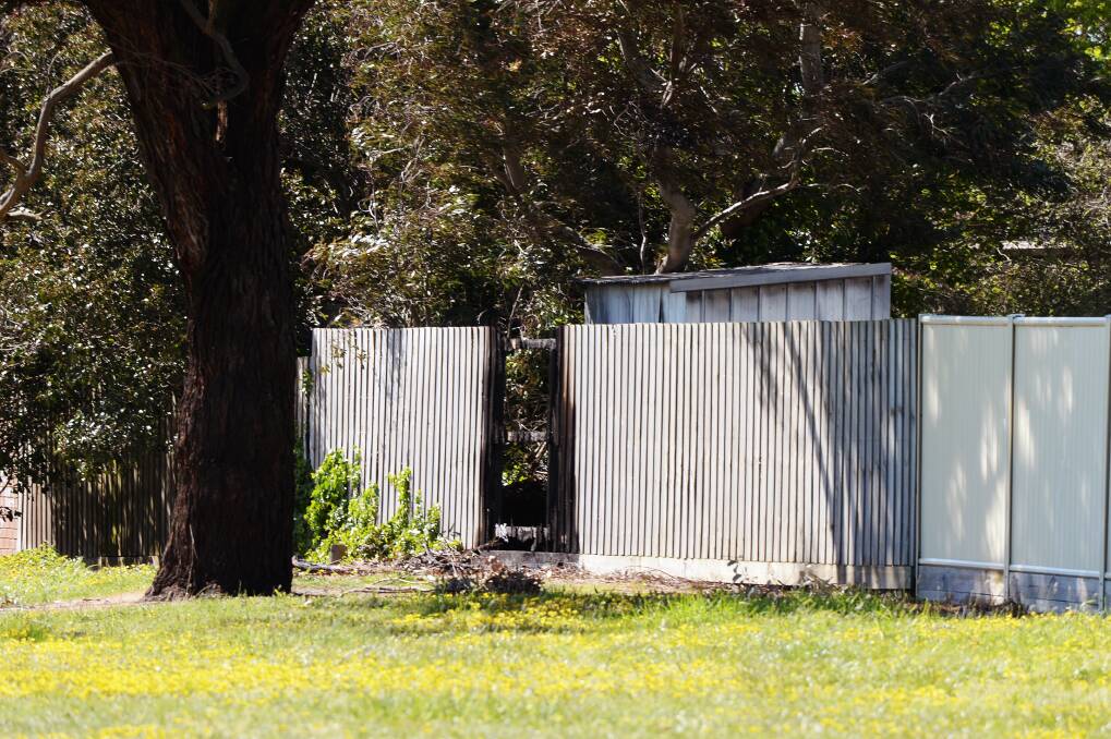 The fence and shed damaged in the fire. Picture: Kate Healy