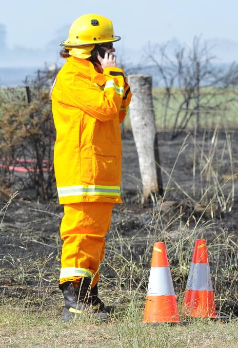 Investigation: A firefighter stands at an ignition point at a fire. Photo: Lachlan Bence.