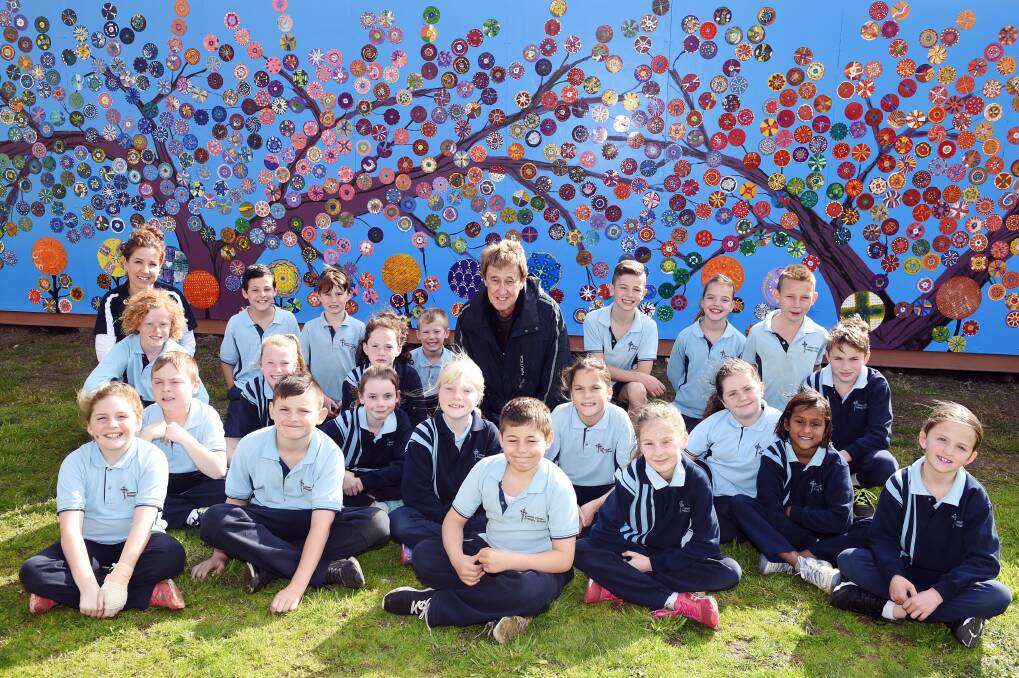 COLOUR: Grade 3/4 students from Lumen Christi with their art teacher Teresa Skrypko and artist Max Darby in front of the bright mural. Picture: Kate Healy 
