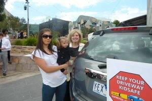 ALERT: Melanie Barbera with daughter Sierra and Minister for Children Wendy Lovell place the first of 95,000 vehicle safety stickers yesterday.