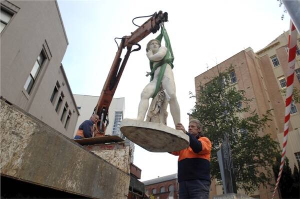 DELICATE WORK: Edd  Smithman,  right, guides the vandalised statue of Perseus on to the back of a truck with the help of Daryl Wilson. Picture: Eugene Hyland