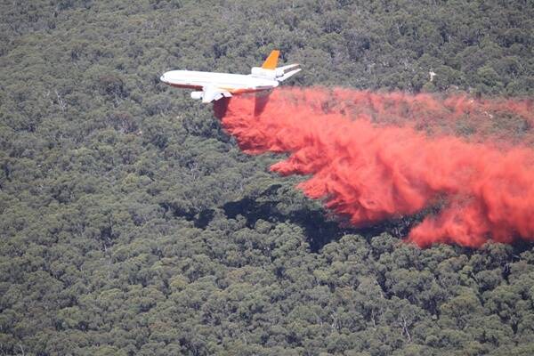 FIRE WEAPON: The DC-10 dumps its load of fire retardant across the controlled burn in  the Enfield State Forest yesterday.  Pictures: CFA