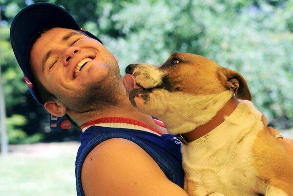 North Ballarat Rebels' Andrew Hooper at home with his dog after hearing the good news. Picture: Jeremy Bannister