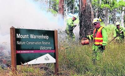Burn-off:  Acting land manager Mathew Sobey lights grass at Mt Warrenheip as DSE and Parks Victoria conduct a one-hectare trial burn to try to stimulate growth.