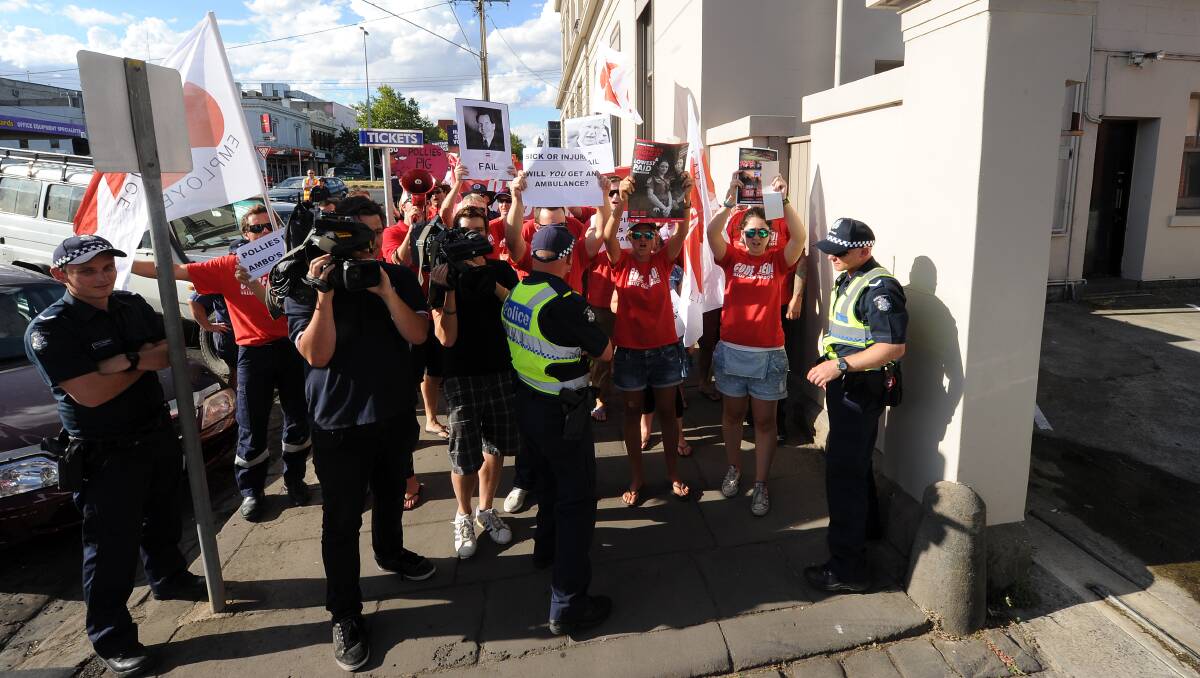 ANGRY: Ambulance officers and firefighters protest outside Western Victoria MP Simon Ramsay’s Dana Street office in Ballarat during a visit by the Premier Denis Napthine yesterday. PICTURE: JUSTIN WHITELOCK