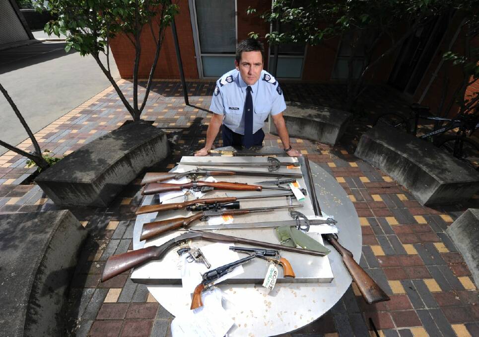 Acting Senior Sergeant Paul Kinna with some surrendered weapons.